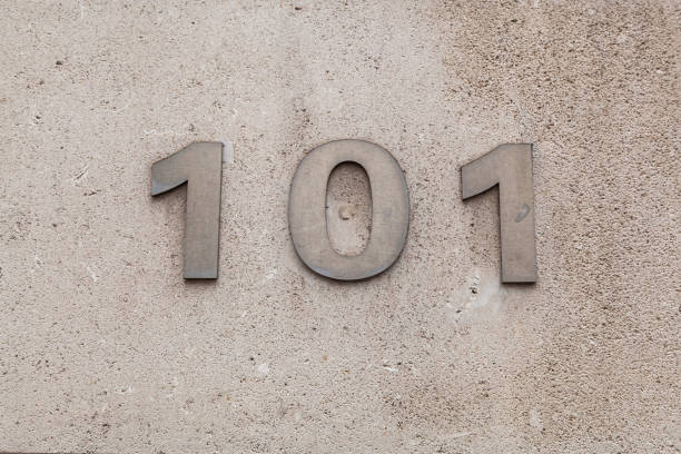 istock 101 numerals in brushed cast steel fixed against a grey cement block. 1480895604