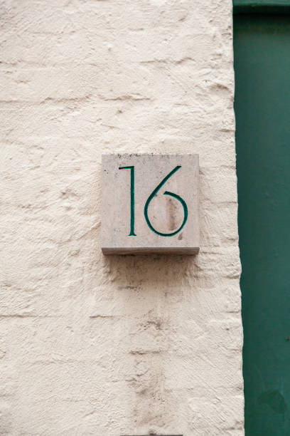 istock 16 sandstone decorative number plaque on white rendered cement house facade. 1480895619