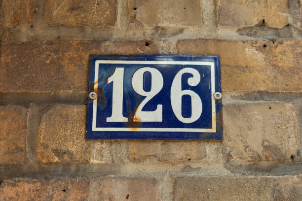 istock 126 number on blue metal plaque on cream brick facade. 1480895622
