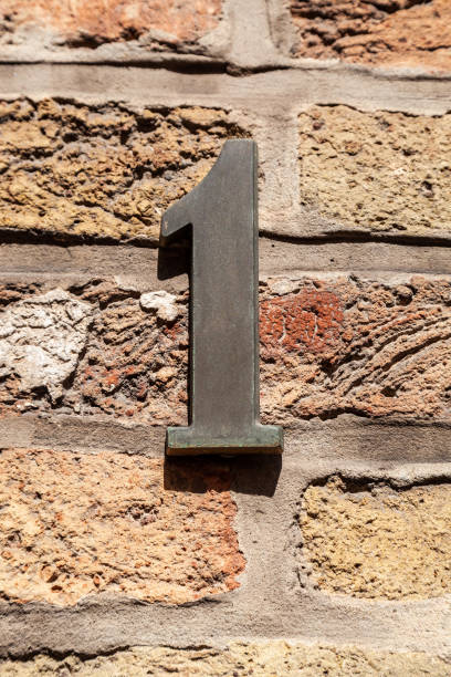 istock 1 numerals in cast steel fixed against a cream brick wall. 1480895632
