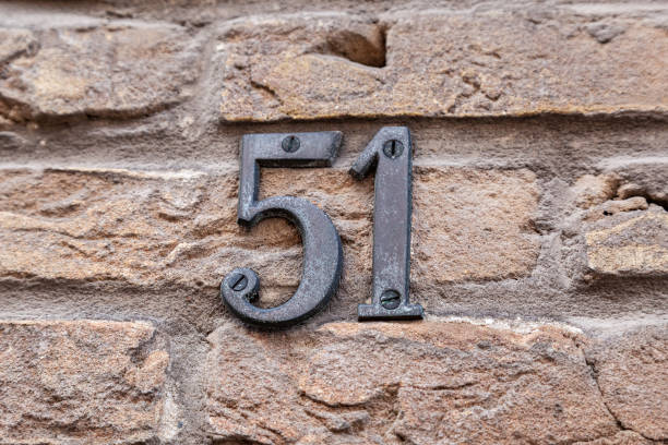 istock 51 numerals in cast steel fixed against a cream brick wall. 1480895633