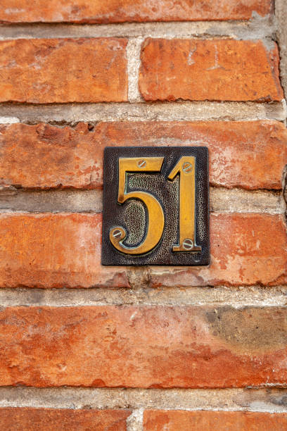 istock 51 number on black pressed metal plaque on red brick facade. 1480895634