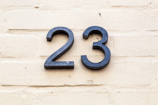 istock 23 numerals in cast steel fixed against a cream painted rendered brick wall. 1480895647