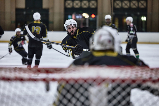 Sports, hockey and men playing game, workout or training as a team on an ice rink at stadium. Fitness, teamwork and male athletes practicing a strategy, skill or exercise for a match at indoor arena.