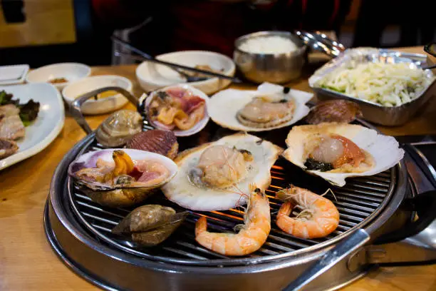 Photo of Gourmet food grilled roasted seafood and shell fried burn for korean people traveler travel visit and taste eat drinks cuisine in local restaurant at Hueundae Street Food Market in Busan, South Korea