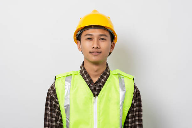 Portrait of smiling young asian construction worker isolated on white background