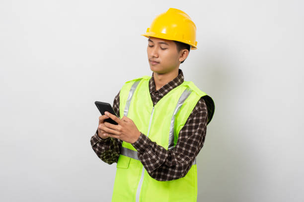 istock Young asian construction worker smiling happy using smartphone isolated on white background 1480903653