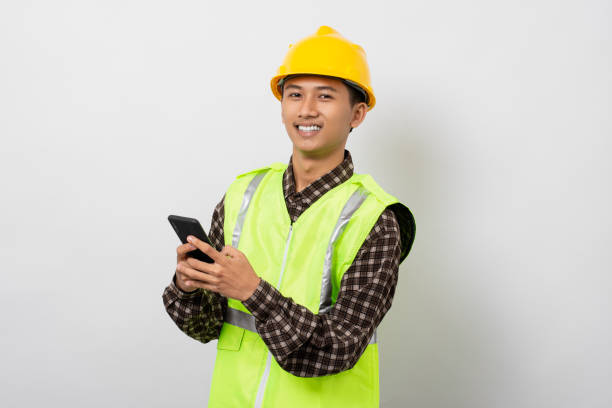 istock Young asian construction worker smiling happy using smartphone isolated on white background 1480903656