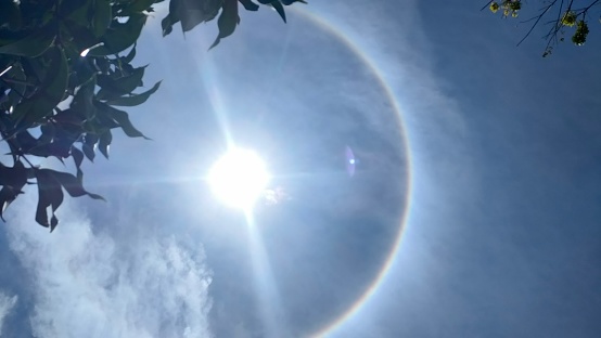 photo of the sun surrounded by a full rainbow