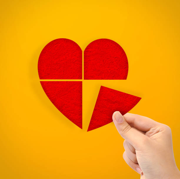 istock Hand holding cut out heart paper shape on yellow background 1480910421