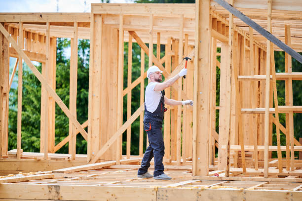 istock Carpenter hammering nail while constructing wooden frame two-story house near the forest. 1480913968