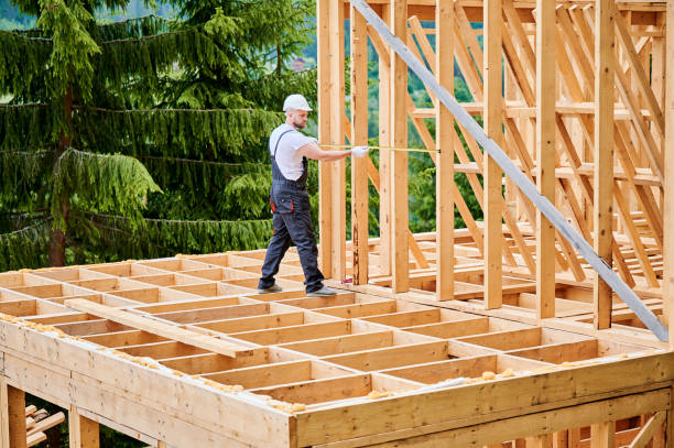 istock Carpenter measures distance with tape measure while building wooden frame house. 1480913985