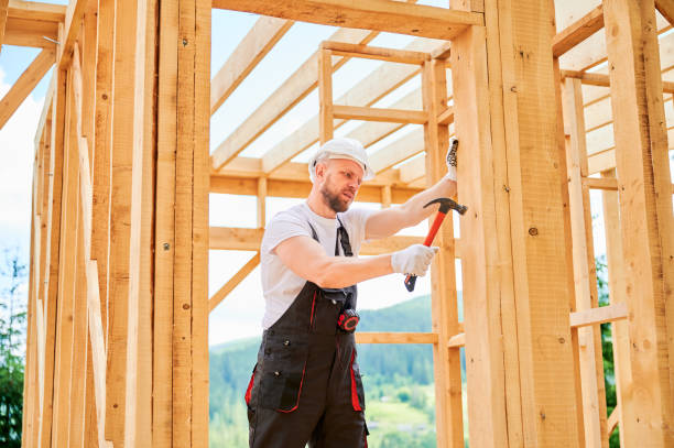 istock Carpenter hammering nail while constructing wooden frame two-story house near the forest. 1480914021