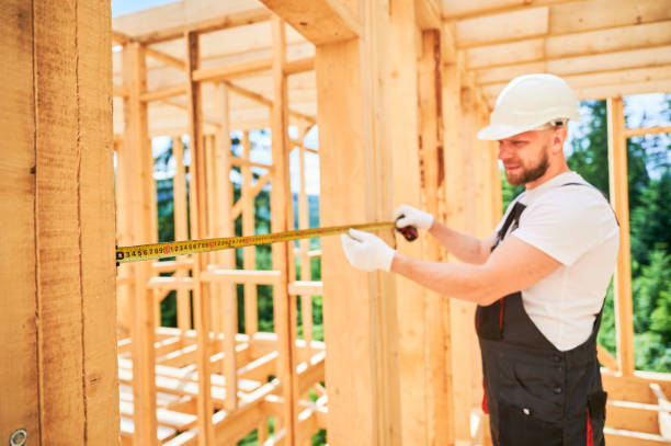 istock Carpenter measures distance with tape measure while building wooden frame house. 1480914030