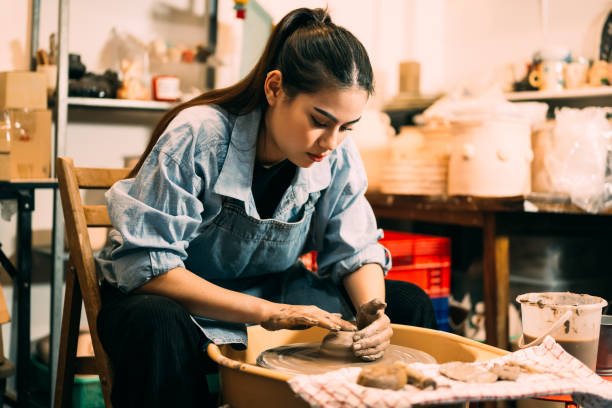 istock Potter making jug of clay on potter wheel circle in workshop 1480915048