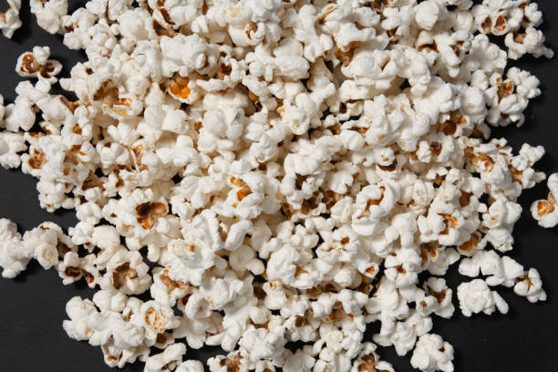 uma tigela de pipoca recém-cozida em um fundo preto, textura de pipoca - popcorn black dietary fiber refreshment - fotografias e filmes do acervo