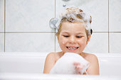 istock Cute child with shampoo foam and bubbles on hair taking bath. Portrait of happy smiling preschool girl health care and hygiene concept. Washes hair by herself. 1480920682