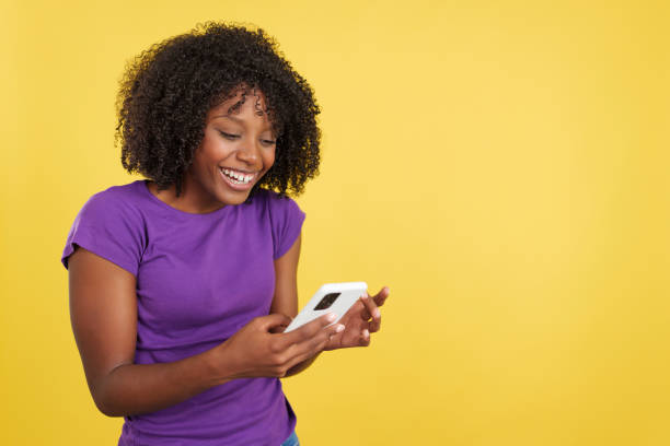 istock Happy woman with afro hair smiling while reading a mobile 1480920741