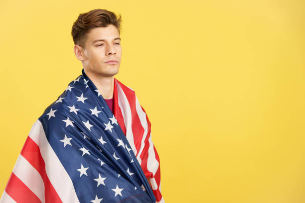 istock Handsome serious man wrapping with a United States national flag 1480920767