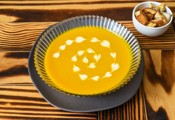 istock Pumpkin Soup on wooden table with crackers side view 1480927242