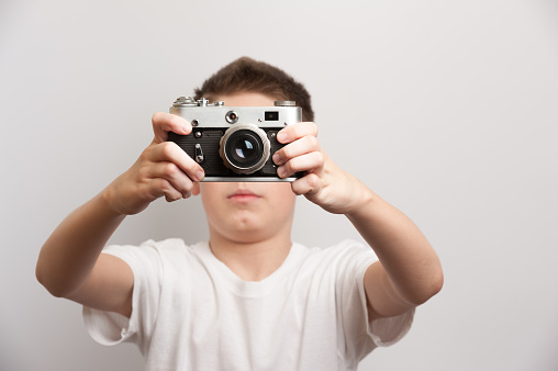 Young artist with retro camera during a shooting process