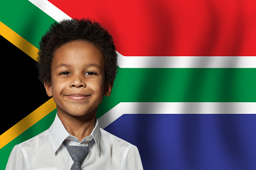 South African kid boy on flag of South Africa background. Education and childhood concept