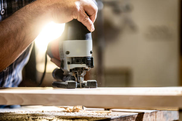 istock Craftsman holding hand saw and cutting wood 1480934175