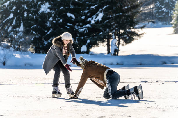 istock Woman helping fallen man to stand up while ice skating 1480934370
