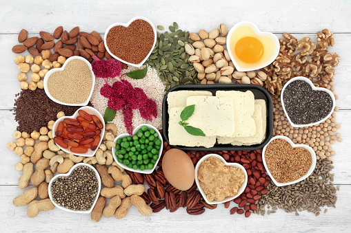 Vegetarian healthy heart food high in lipids essential fatty acids containing unsaturated good fats for low cholesterol levels with nuts, seeds, dairy, vitamin e capsules, vegetables and grain.