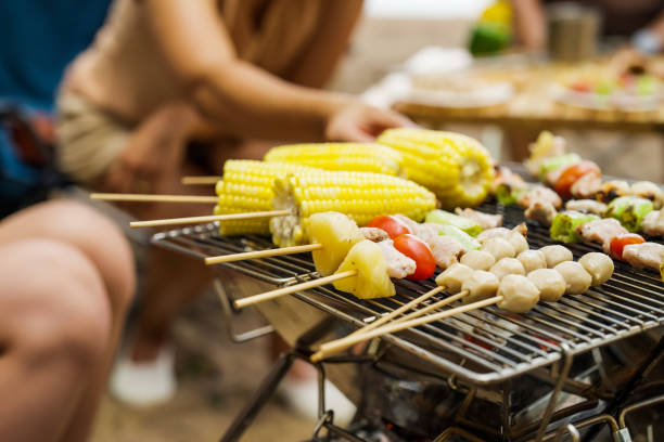 Happy Asian family with barbecue party at camping beach together Happy Asian family with barbecue party at camping beach together, Cooking grilled barbecue for dinner during camping on summer beach, Holiday and travel concept family bbq beach stock pictures, royalty-free photos & images