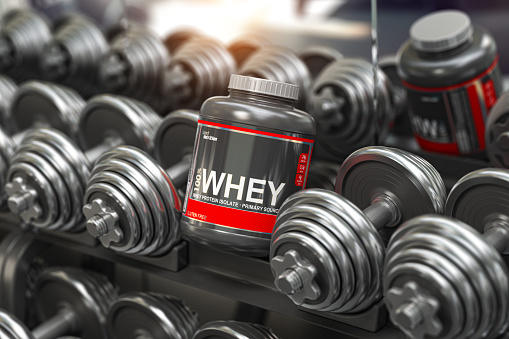 Whey protein powder in a row of dumbbells in a gym. Sports bodybuilding supplements and nutrition. 3d illustration