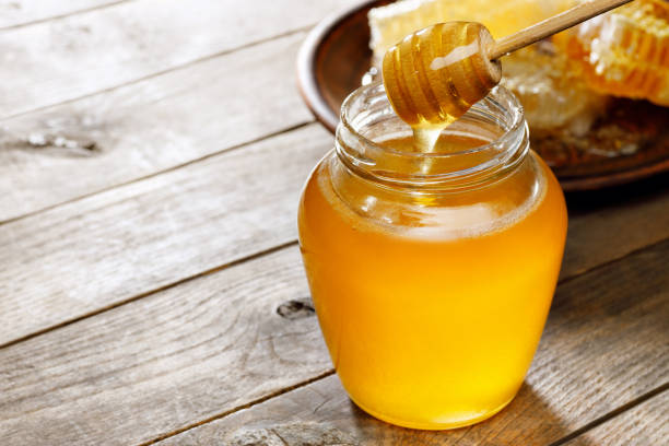 istock glass jar of honey with honeycomb table 1480942688