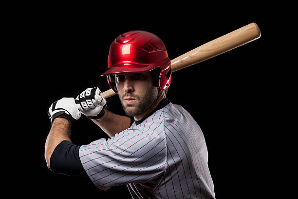 baseball Player Baseball Player with a bat on a black background. Studio Shot. baseball hitter stock pictures, royalty-free photos & images