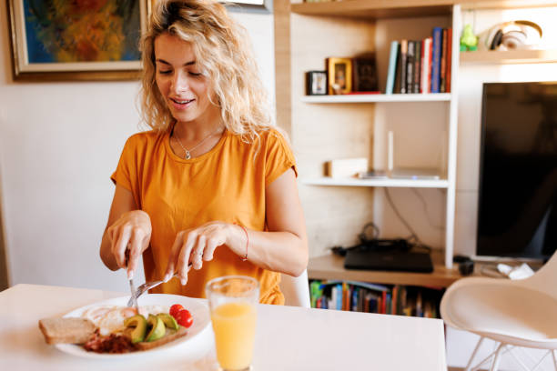 istock Smiling young woman enjoying breakfast at home 1480950423