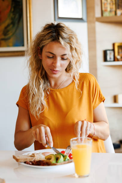 istock Smiling young woman enjoying breakfast at home 1480951228