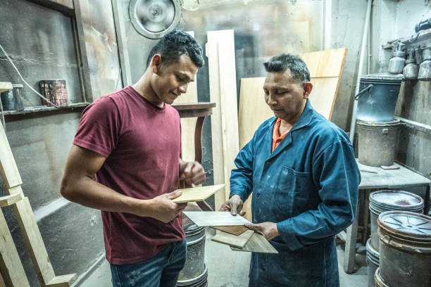 istock Father and son talking while analyzing pieces of wood at carpentry 1480951581