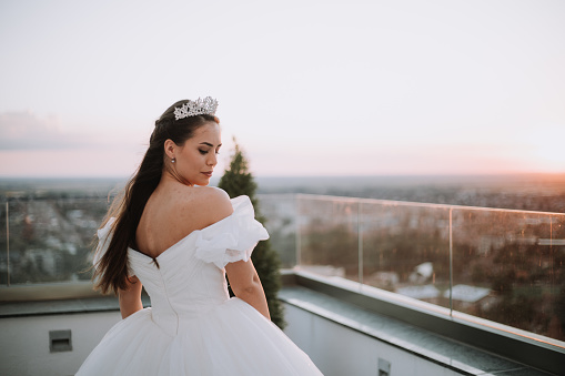 Beautiful bride posing in white princess dress with crown.