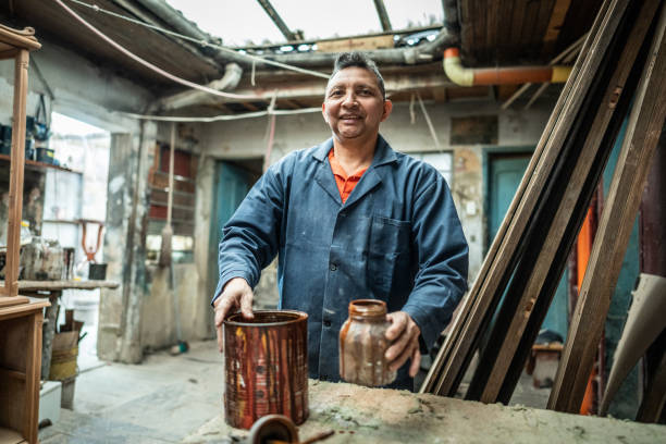 Portrait of a mature painter man at carpentry workshop