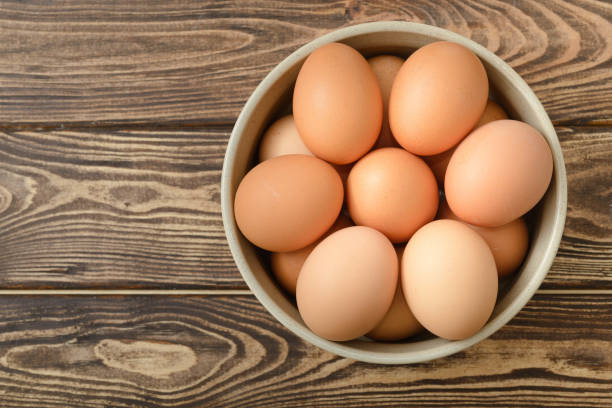 istock Top view of eggs in a bowl on wooden background 1480953355