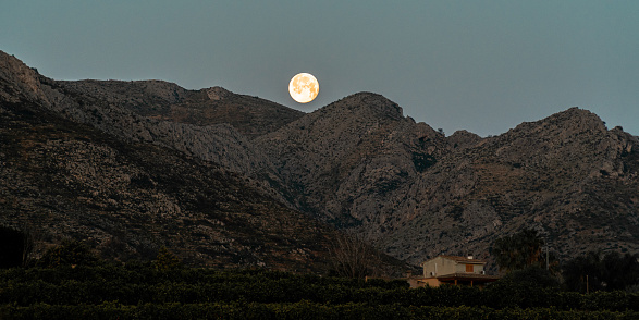 The full moon over the mountains at dawn