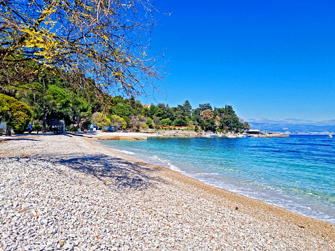 Beautiful pebble beach Medveja, near Opatija, in background city of Rijeka