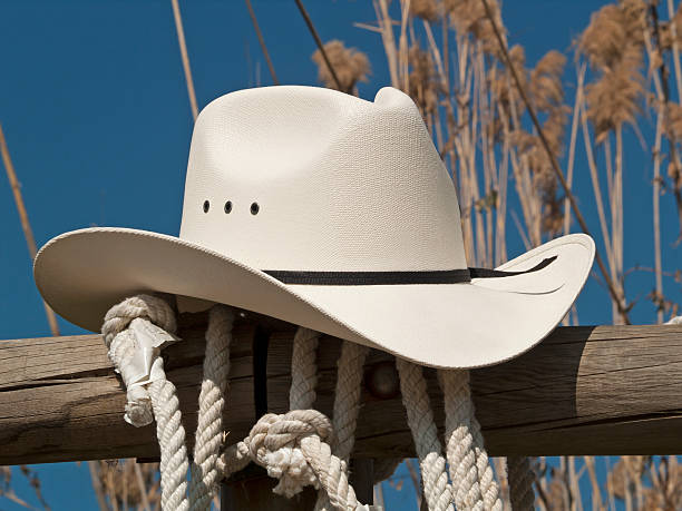 Close up of a white cowboy hat and rope in a country fence