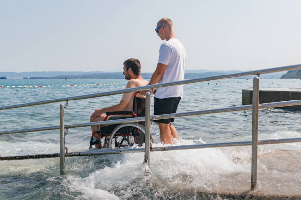 istock Man with disability at beach goes to swimm 1480969057