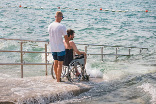 istock Man with disability at beach goes to swimm 1480969180