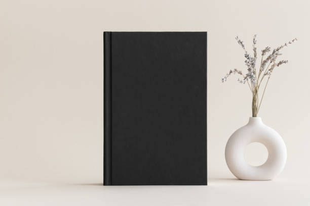istock Black book mockup with a lavender decoration on the soft yellow background. 1480969297
