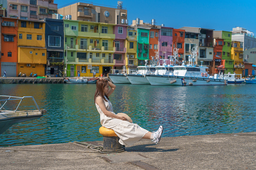 woman traveler visiting in Taiwan, Tourist with hat sightseeing in Keelung, Colorful Zhengbin Fishing Port, landmark and popular attractions near Taipei city . Asia Travel concept