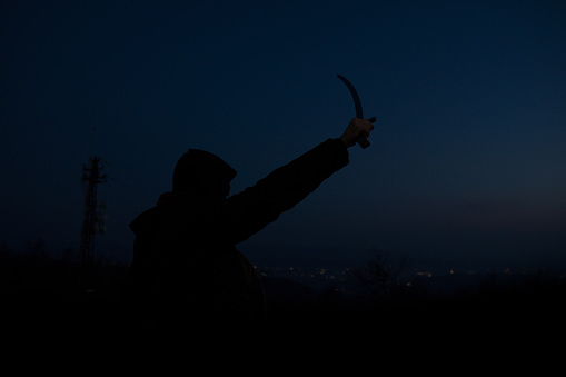 a knight in darkness holds a sword aloft