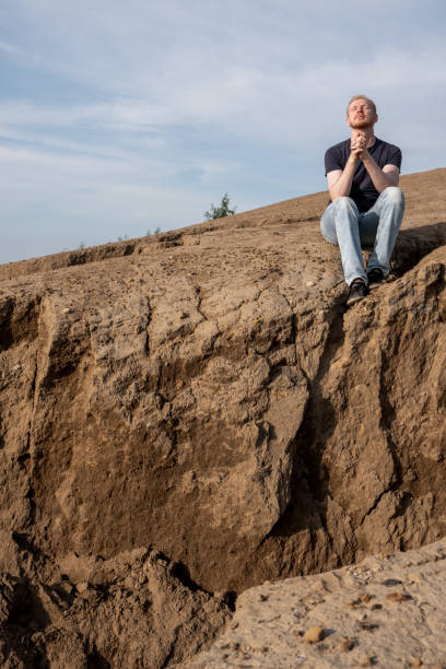 istock A man surrounded by mountains. Hope, faith and prayer 1480974691