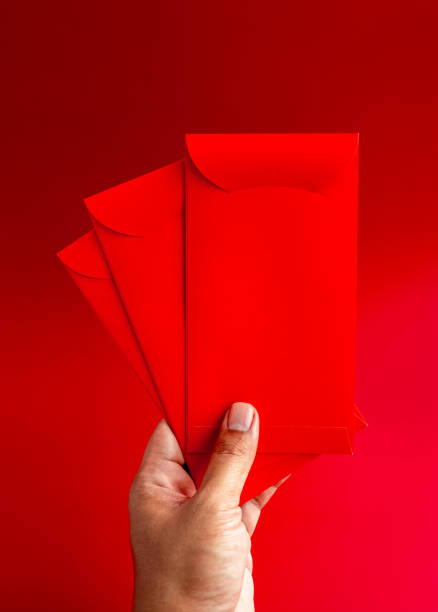 istock Three red envelope holding by hand isolated on red background, vertical style. 3 Hongbao packets for lucky money gift in Chinese lunar, new year on January month, wedding red packet. 1480974798
