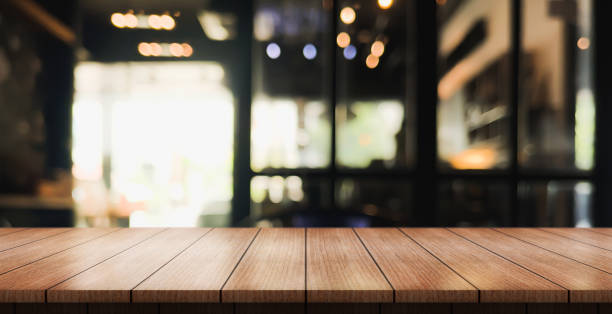 istock Empty wooden table top with lights bokeh on blur restaurant background. 1480974985
